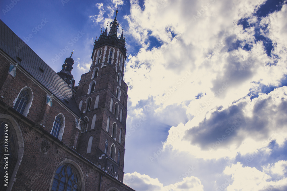old medieval church and tower in evening twilight time before sunset on blue sky with clouds background
