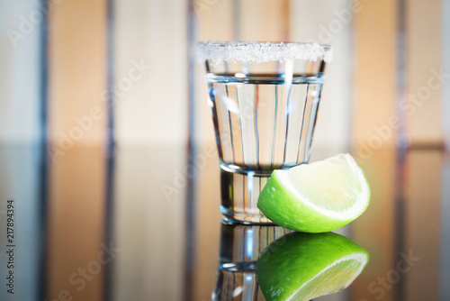 Tequila and slice of lime on a blurred background photo