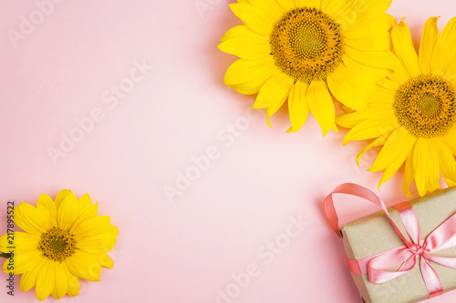 Fototapeta Naklejka Na Ścianę i Meble -  Pink background with yellow sunflowers and gift box.