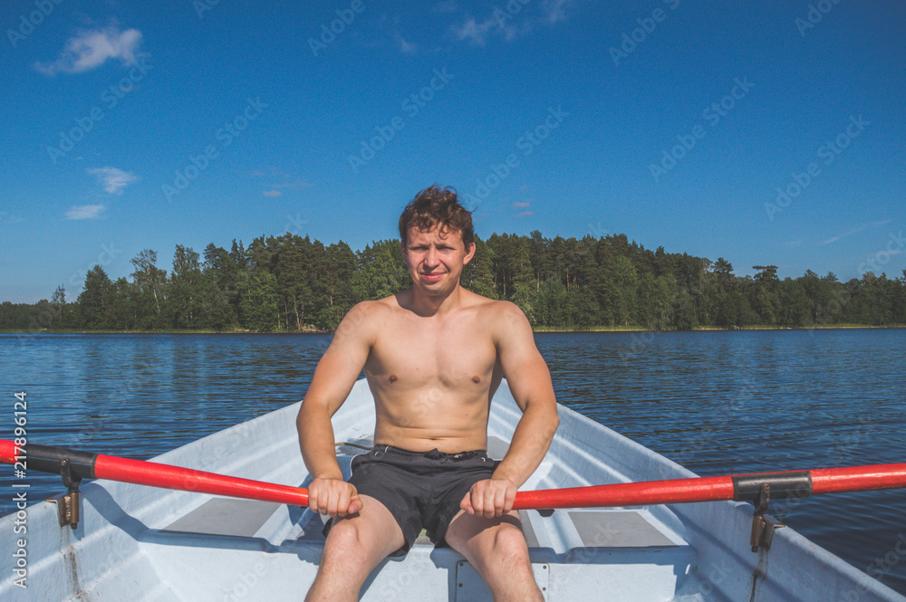 the man in a boat rowing on the lake the man in a boat rowing on the lake