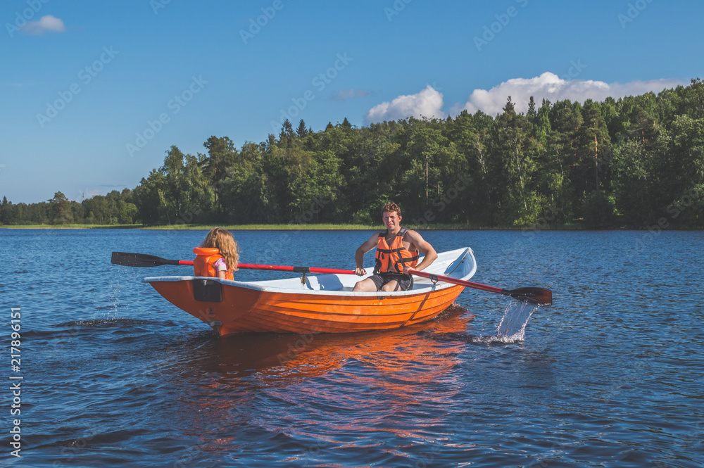 man and the child, the girl in the boat, rowing on the lake