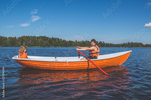 man and the child, the girl in the boat, rowing on the lake © dmitrypk