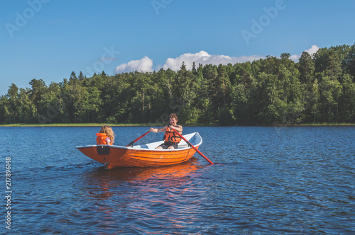 man and the child, the girl in the boat, rowing on the lake
