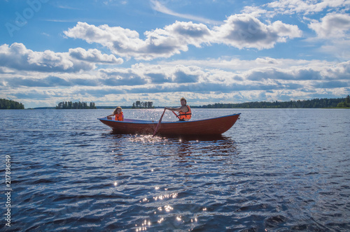 man and the child, the girl in the boat, rowing on the lake