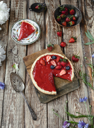 delicious red strawberry pie with berries on wooden table