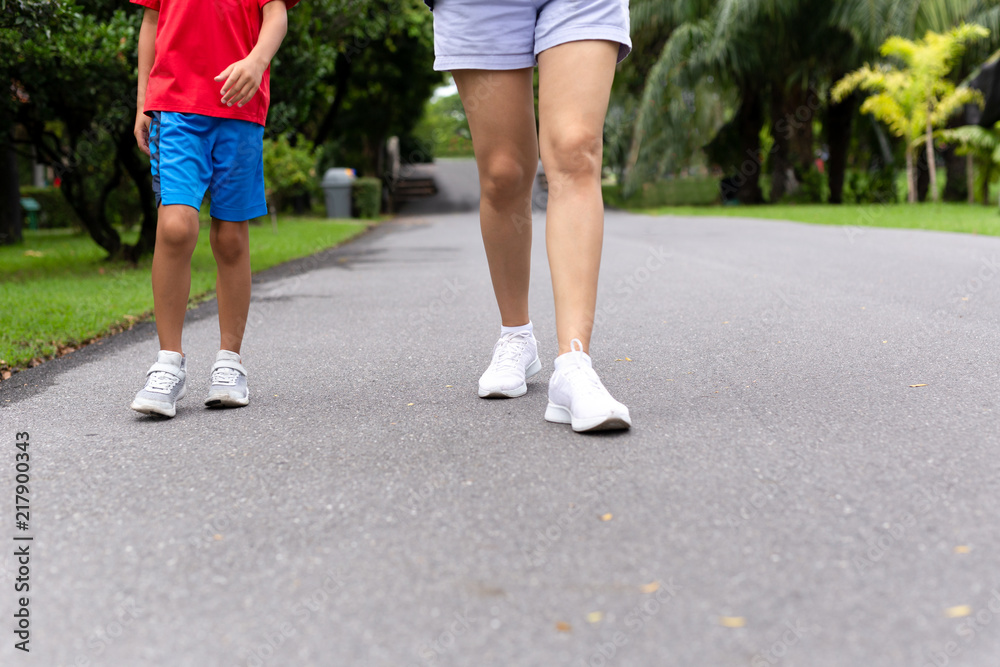 Mother and son walking in the park in summer.