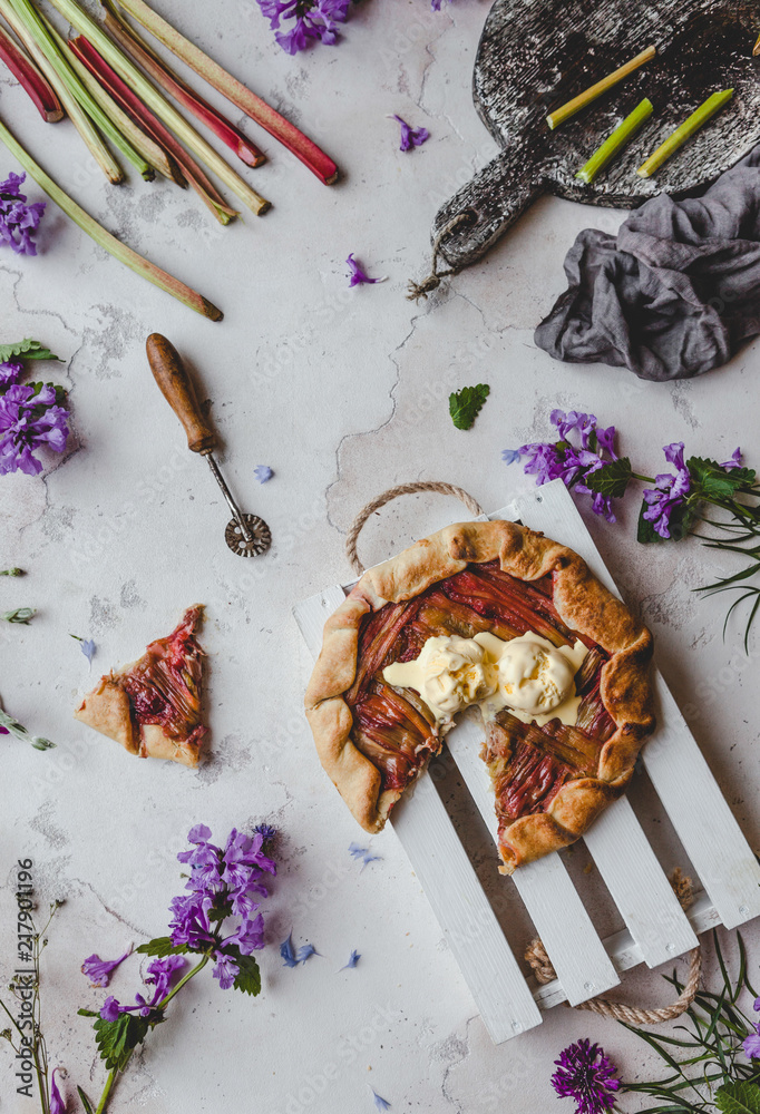 Fototapeta top view of delicious rhubarb pie on table with violet flowers
