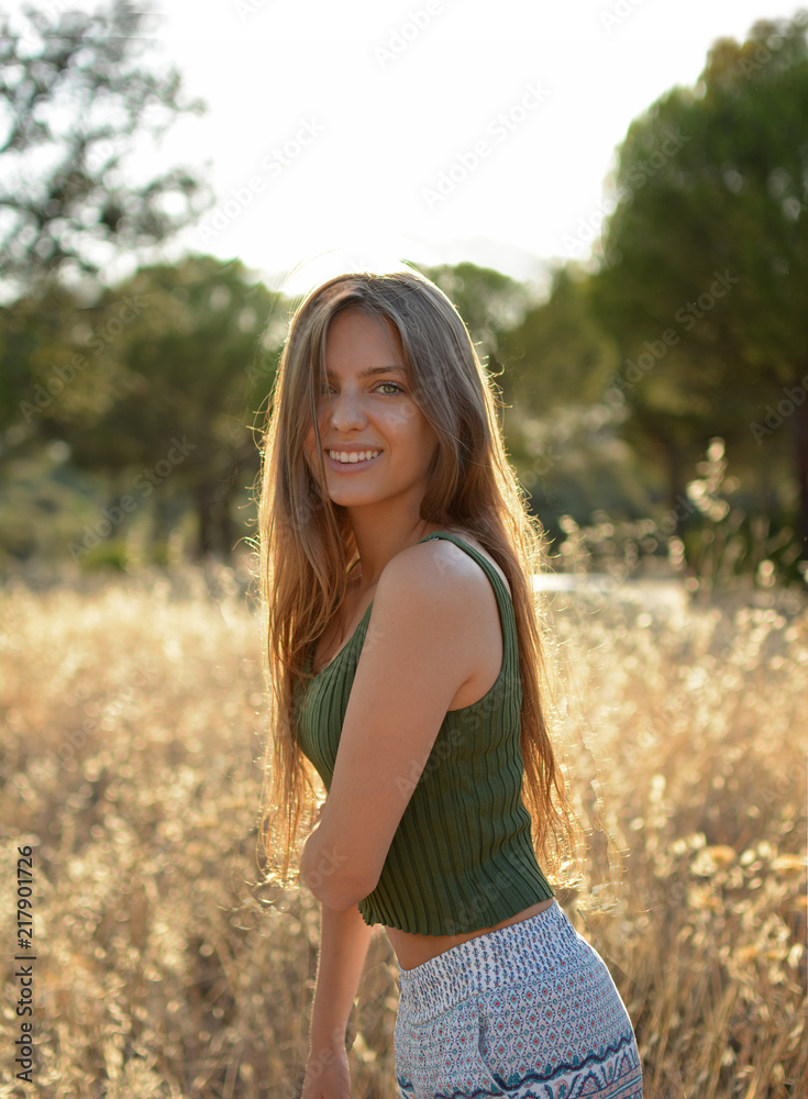chica sonriente en el campo con pelo largo y un camiseta verde chica sonriente en el campo con pelo largo y un camiseta verde
