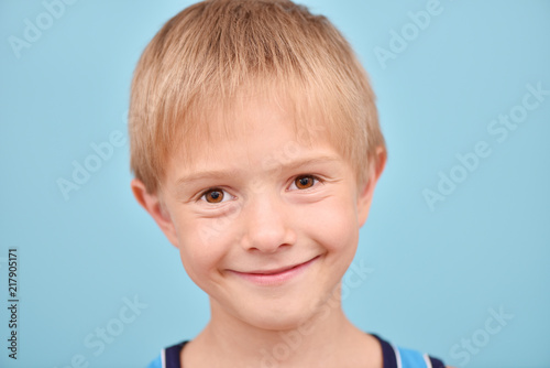 A boy on a blue background. Isolated portrait of a teenager.