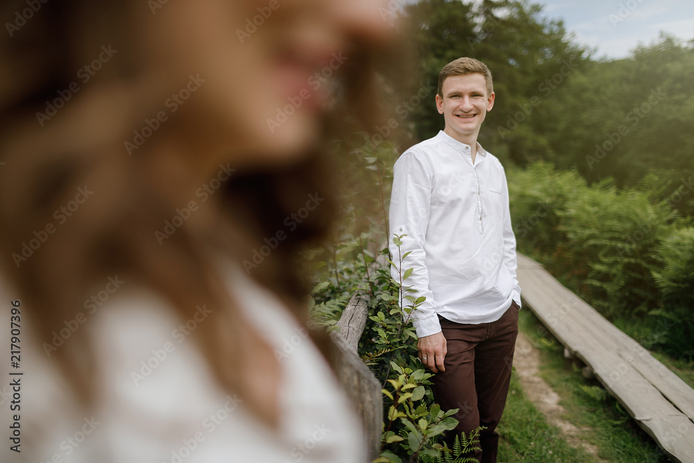 Fototapeta premium Happy pregnant family having fun time in summer nature. 
