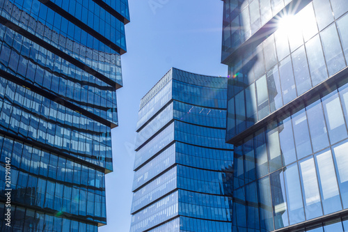 Glass facade of the buildings with a blue sky.