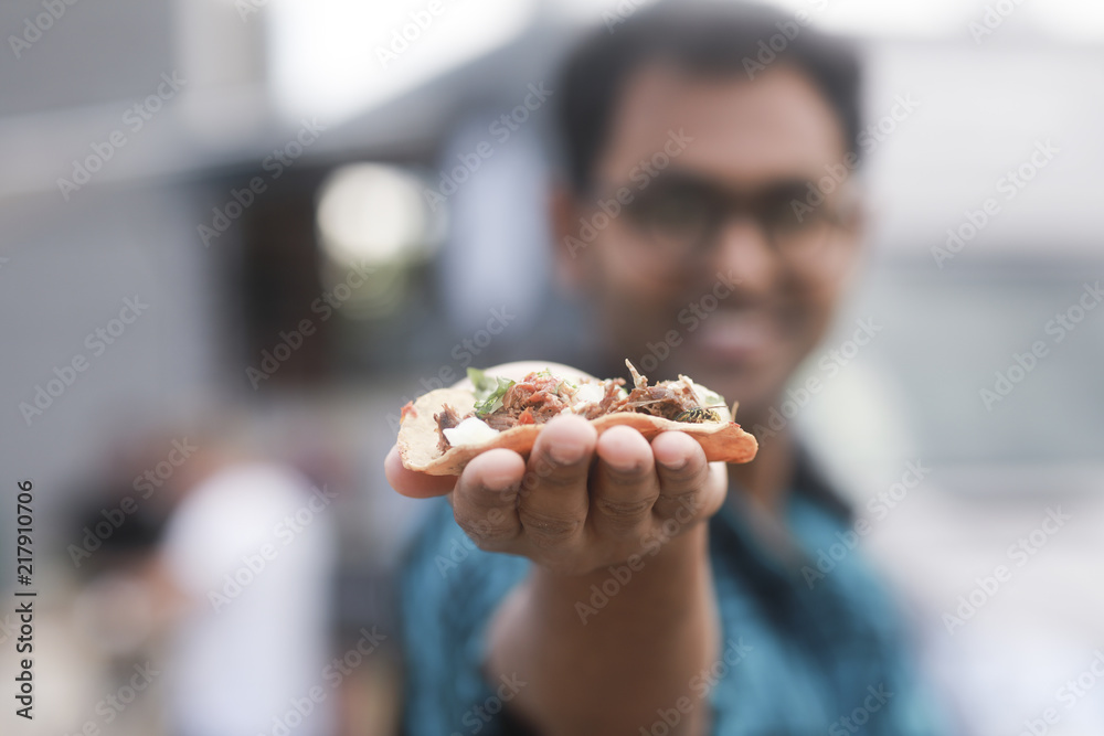 Taco in der Hand eines jungen Mannes Taco in der Hand eines jungen Mannes