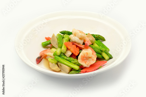 Stir fried asparagus with shrimp on white plate and white background.