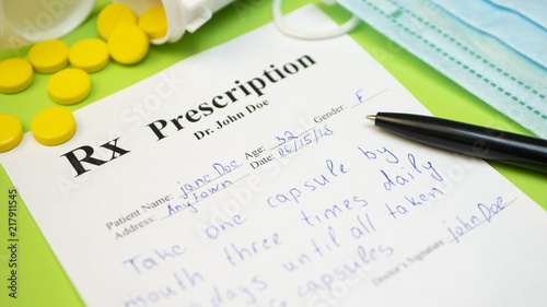 Prescription for tablet pills or drugs on green background with bottle and yellow tablets or pills and medical mask