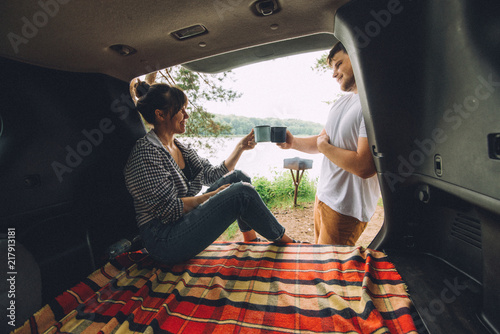 couple resting outside. car travel concept. sitting in trunk