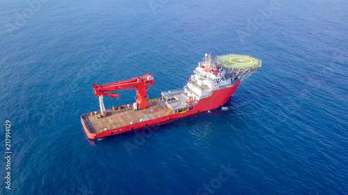 Fotografie Aerial image of a Medium size red Offshore supply ship with a Helipad and a larg