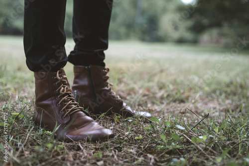 Close up leather boots of hipster man. Male legs in black jeans and brown leather shoes. concept of fashion and lifestyle.