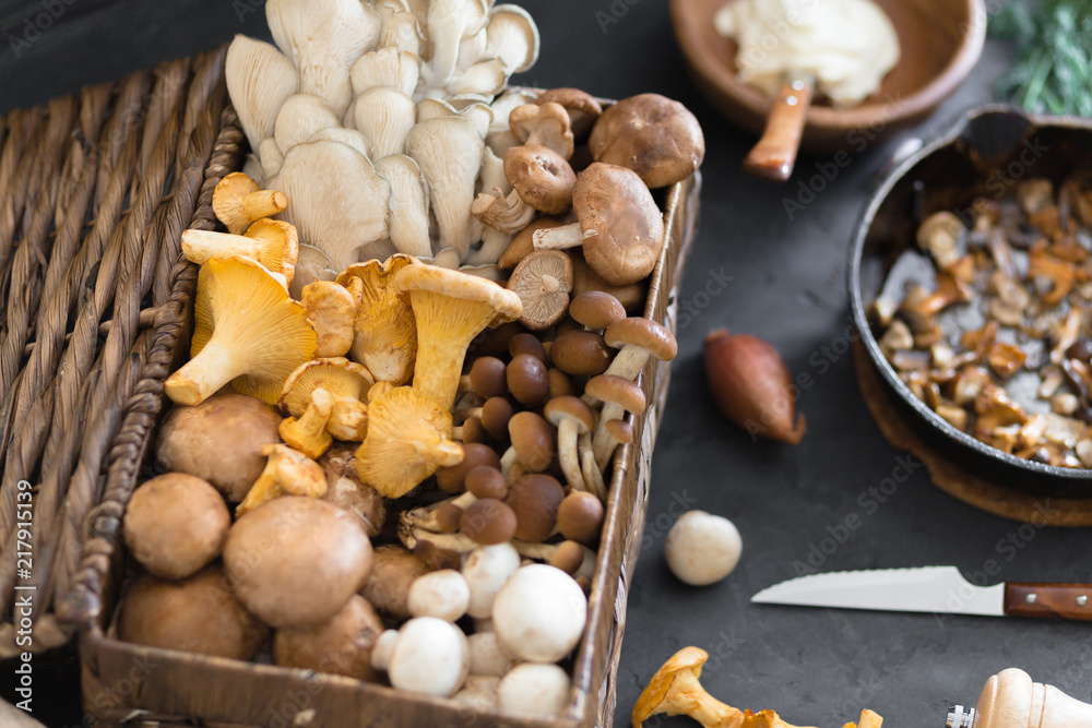 Top view of preparation and frying of edible wild mushrooms, food photo. Mix of chanterelle, portobello, shiitake in Cast-iron pan. Cooking with spices, butter, parsley, onion, leek, garlic. Top view of preparation and frying of edible wild mushrooms, food photo. Mix of chanterelle, portobello, shiitake in Cast-iron pan. Cooking with spices, butter, parsley, onion, leek, garlic.