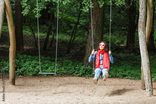 young happy woman lifestyle in the city park having fun swinging at the seesaw