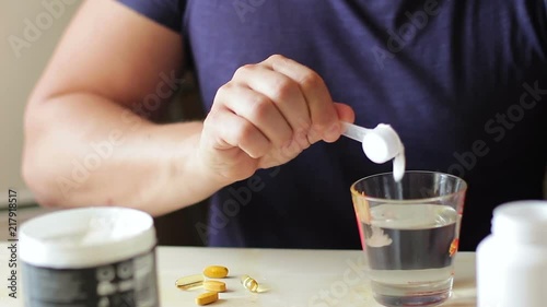 Sports supplements. The athlete prepares a portion of creatine or amino acids for consumption