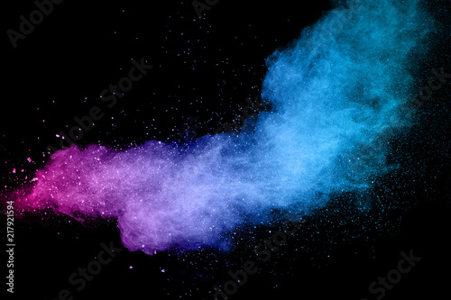 Explosion of color powder on black background. Splash of color powder dust on dark background.