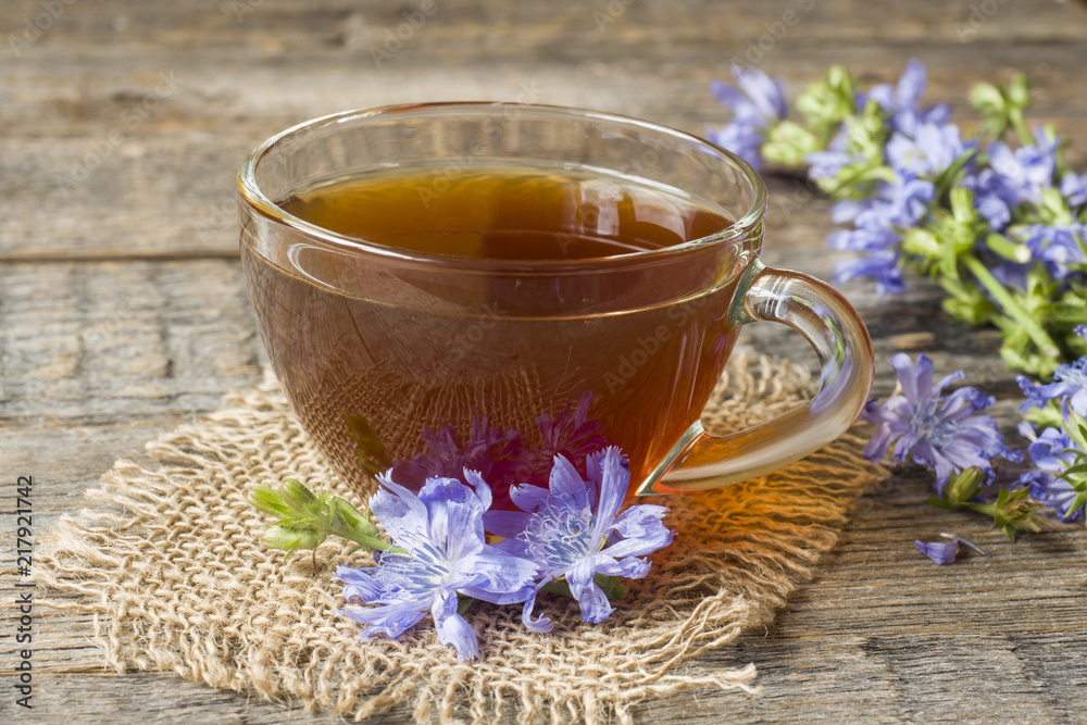 Chicory drink in Cup and flowers on rustic wooden background. Medicinal plant Cichorii. Chicory drink in Cup and flowers on rustic wooden background. Medicinal plant Cichorii.