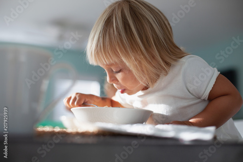 A young girl eating breakfast. 