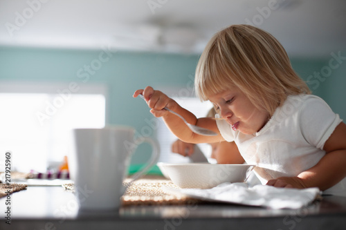 A young girl eating breakfast. 