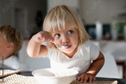 A young girl eating breakfast. 