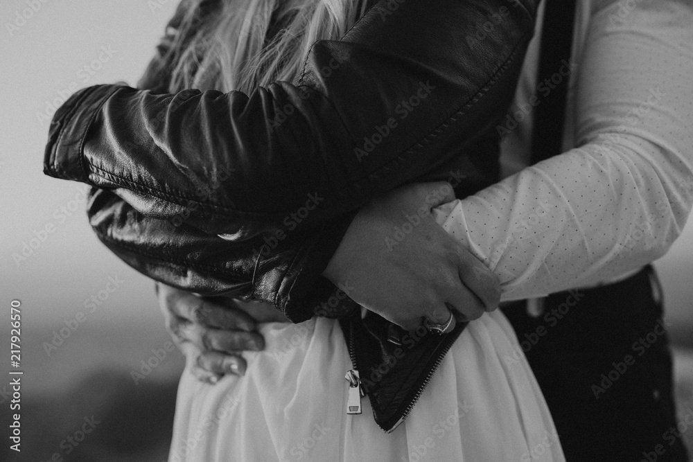 Wedding hipster couple. Bride and groom embracing in the mountains. Close up of hands