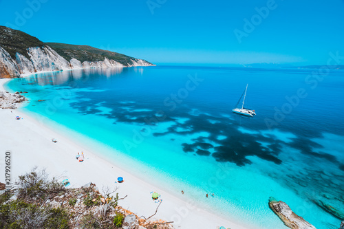 Fototapeta Naklejka Na Ścianę i Meble -  Lonely white catamaran yacht drift in clear blue Caribbean like sea water. Tourists leisure activity on the beach with azure colored shallow lagoon