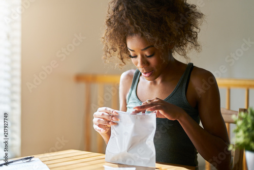 african americna woman opening bag of legal marijuana from dispensary photo
