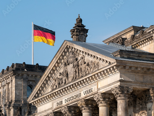 Politics Concept: German Flag Upon The Reichstag Building In Berlin, Germany With Dedication Dem Deutschen Volke, Meaning To The German People