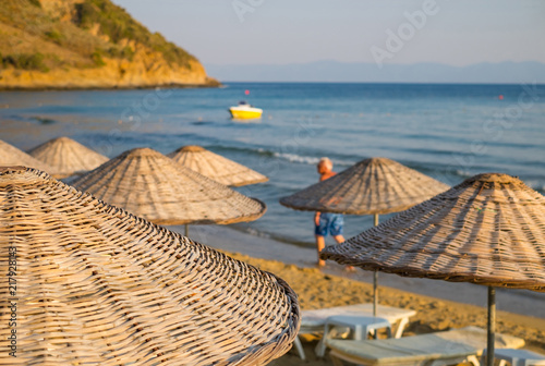 Beach umbrellas and chaise lounges with sea and sky in the background.