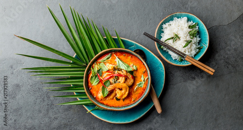 THAI SHRIMPS RED CURRY. Thailand Thai tradition red curry soup with shrimps prawns and coconut milk. Panaeng Curry in blue plate on gray background