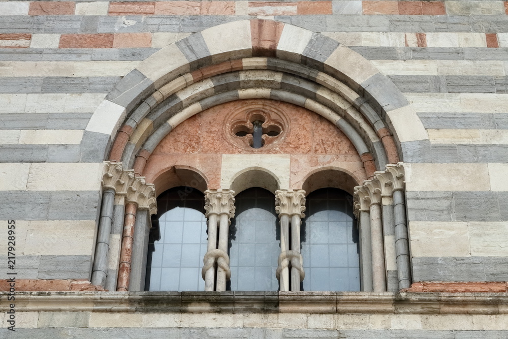 finestra chiesa medievale con colonne di pietra decorate Como, Italia