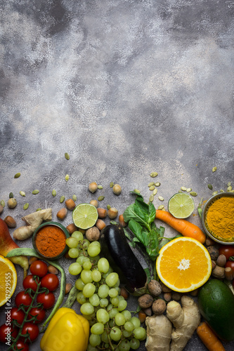 Healthy food background, frame of organic food. Ingredients for healthy cooking: vegetables, fruits, nuts, spices. Balanced diet food on a dark black background. Top view. Copy space on top