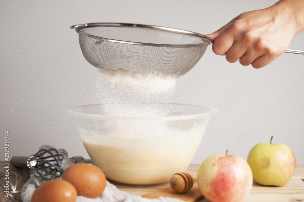 Close-up young woman's hands pourring milk, making pie, cake. Female cooking dough for pie on wooden table. Preparring dessert. Close-up young woman's hands pourring milk, making pie, cake. Female cooking dough for pie on wooden table. Preparring dessert.