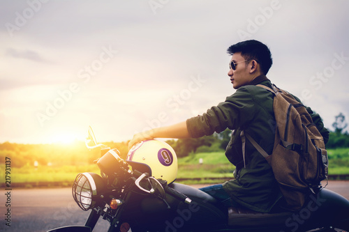 Biker man and motorcycle with river background, Rider moto trip on the street at the riverside, enjoying freedom and active lifestyle.