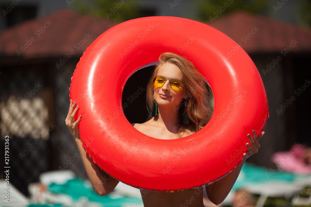 beautiful young girl with a red inflatable circle for a summer swim