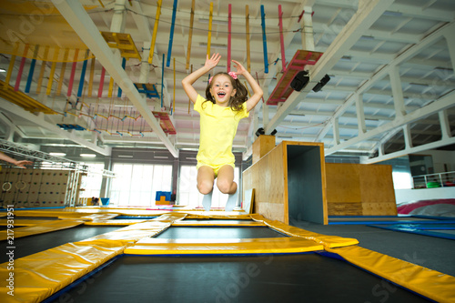 beautiful little girl jumping on a trampoline indoors © Alexandr