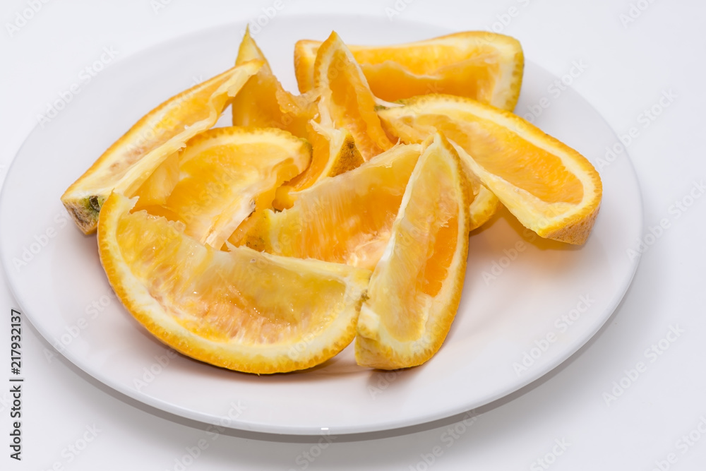 Eaten slliced orange on white plate with white background and room for copy text