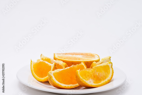 Slices of orange on white plate with white background and room for copy text