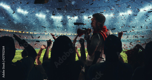 Fans celebrating the success of their favorite sports team on the stands of the professional stadium while it's snowing
