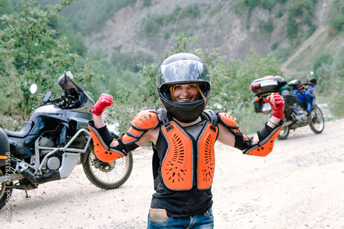 A girl in helmet and body armor stand alone a with two big adventure touring motorcycle with bags and camping equipment, off road travel jorney, traveling together, couple, have a power © Sergey