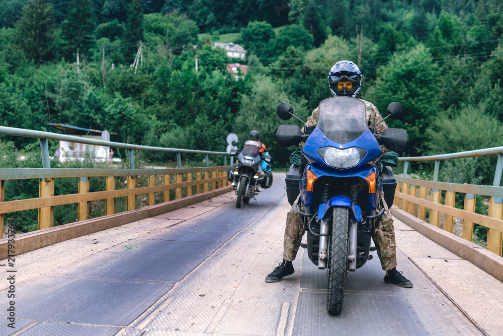 Portrait Motorcyclist man and Adventure Motorbike on the bridge. Motorcycle trip. off road Traveling, Lifestyle Travel vacations sport outdoor concept.