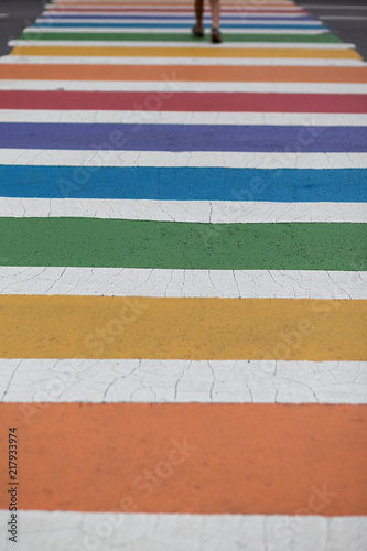 rainbow colored crosswalk. person crosses the street in a colorful zebra. Copy space for your text