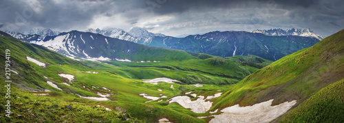 Obraz na płótnie Panoramic view on Svaneti mountains landscape. Hills and mountain in highland. Nature landscape in Georgia. Hills covered green grass and snow. w salonie
