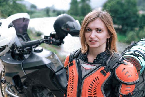 close up portrait girl in body armor with big adventure motorcycle with bags and camping equipment, off road travel jorney, traveling together, couple, mountains dirt road and river