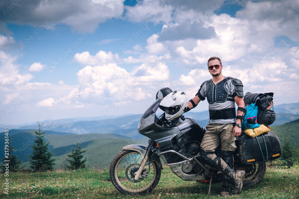 Fototapeta premium Motorcyclist man and Adventure Motorbike on the top of the mountain. Motorcycle trip. off road Traveling, Lifestyle Travel vacations sport outdoor concept.